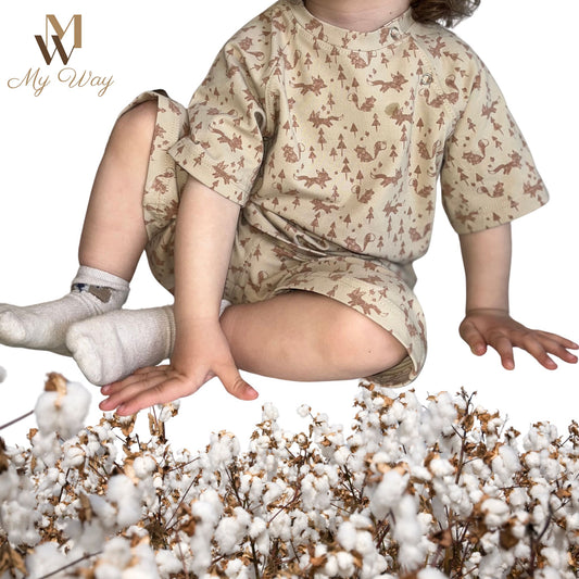 Bild eines Babys in einem organischen Raglanschnit Baumwoll-Kurzarm-T-Shirt und Shorts Set mit Eichhörnchendetails